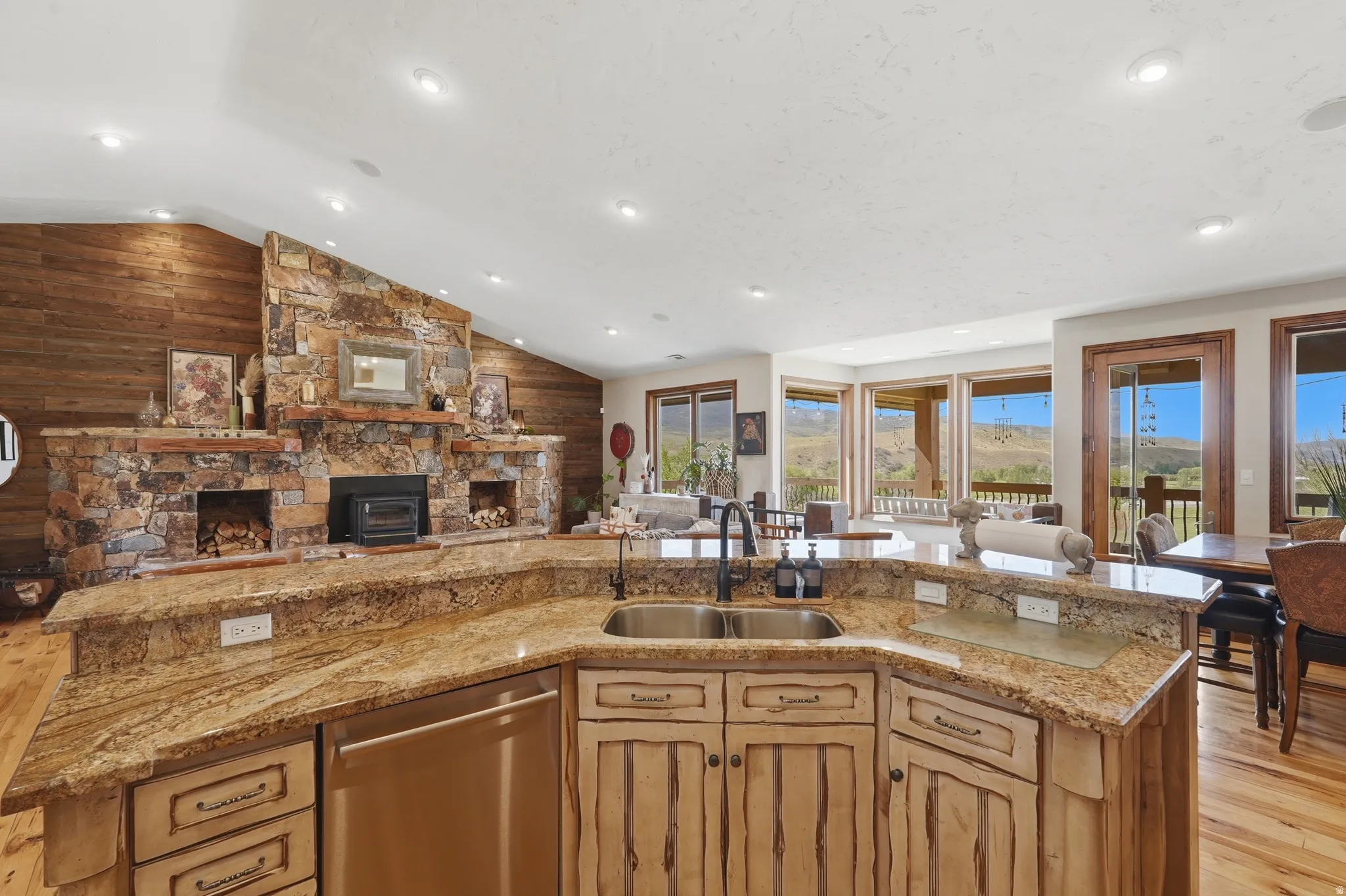 Kitchen island featuring granite countertops, a stainless steel sink with a black faucet, and distressed wood cabinetry