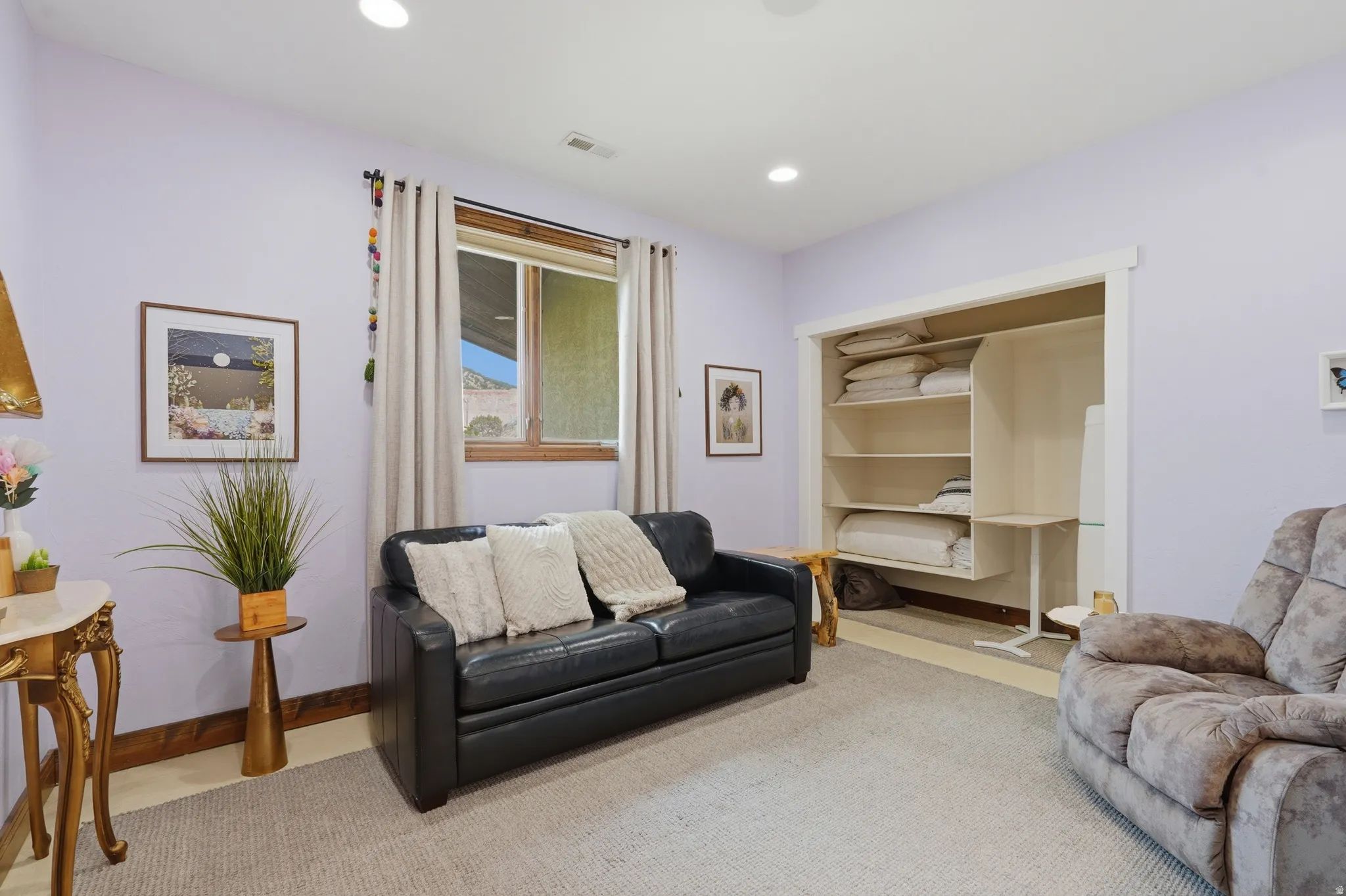 Recessed lighting illuminates this room, featuring a built-in shelving unit for organization