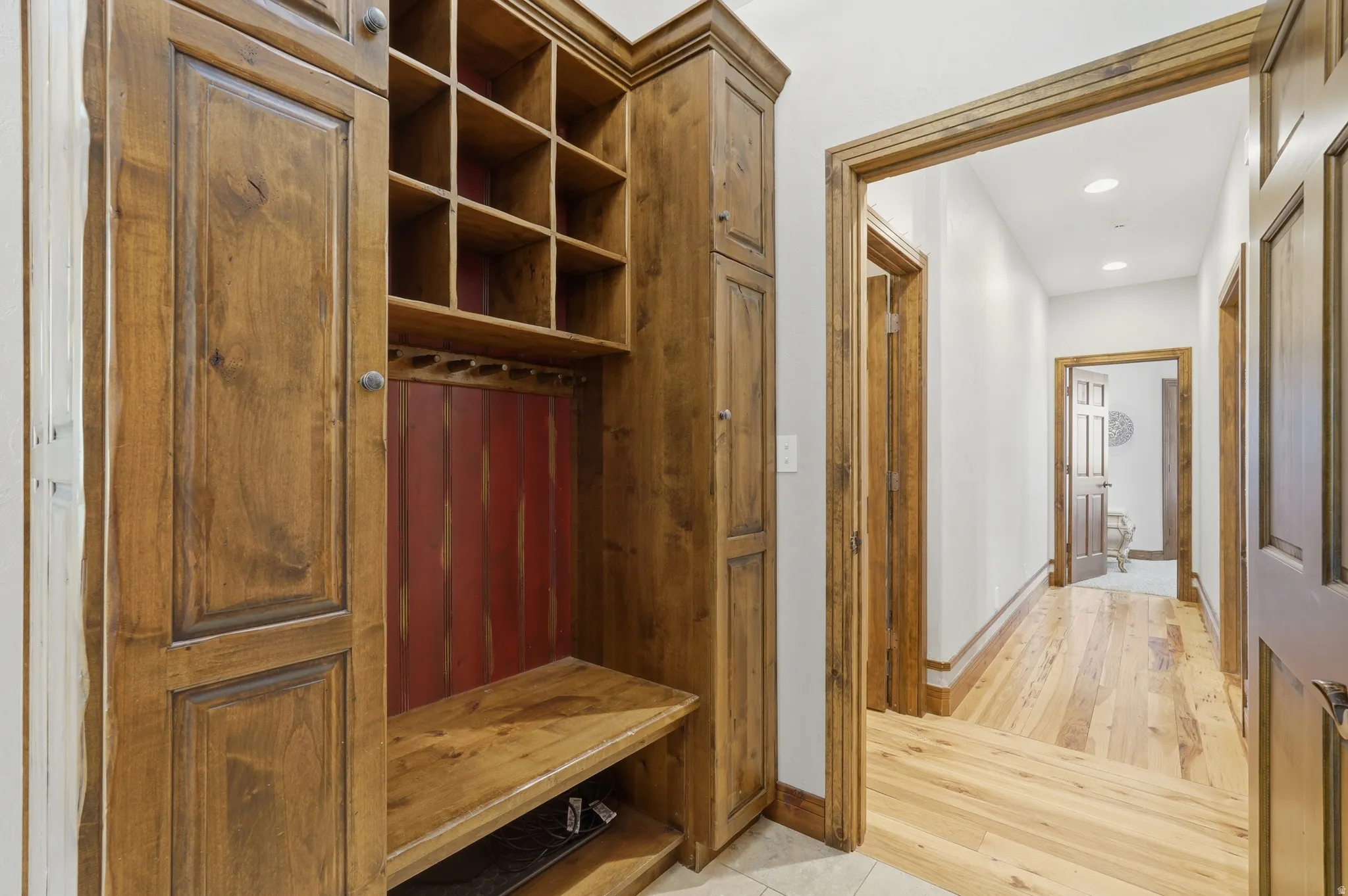 Built-in wood mudroom storage with integrated bench seating, cubbies, and coat hooks