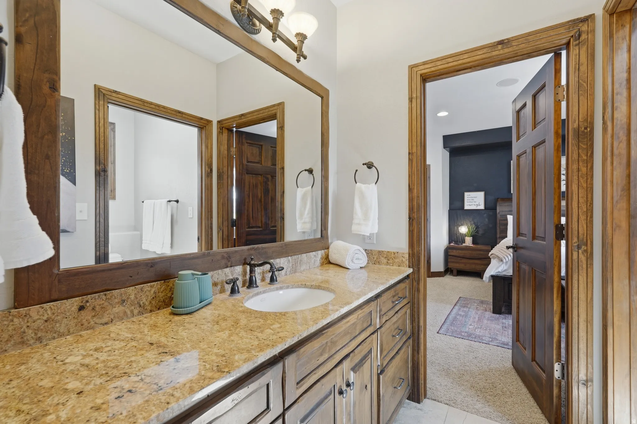 Spacious bathroom vanity featuring a light granite countertop, undermount sink, and oil-rubbed bronze faucet