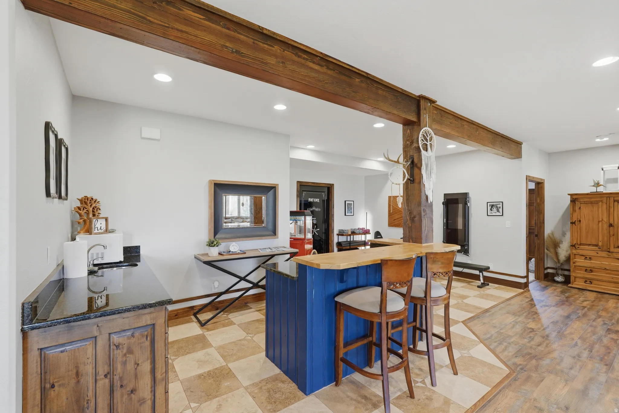 Spacious interior featuring exposed wood beams and recessed lighting