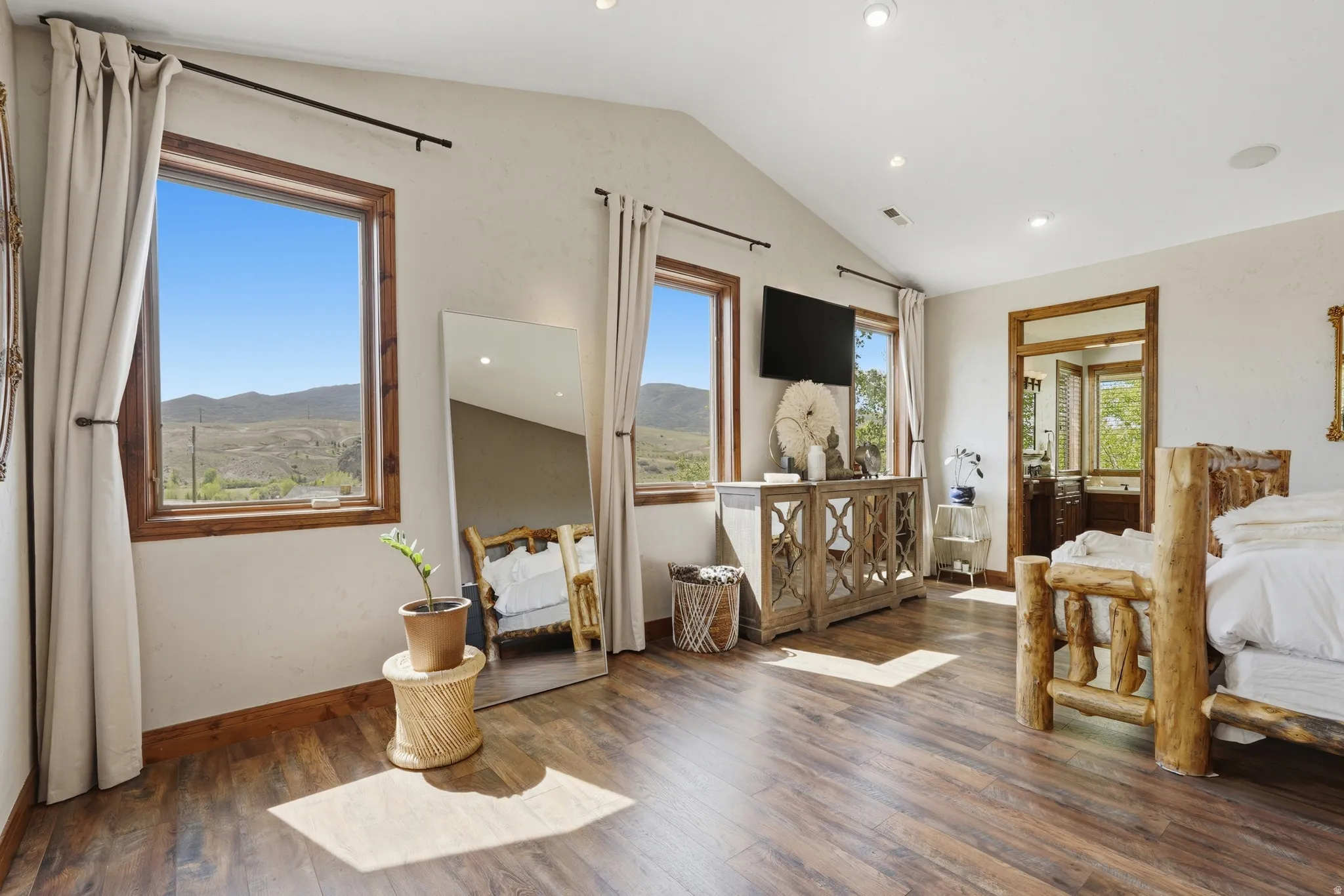 Spacious room featuring wood-finish flooring, vaulted ceiling, and recessed lighting