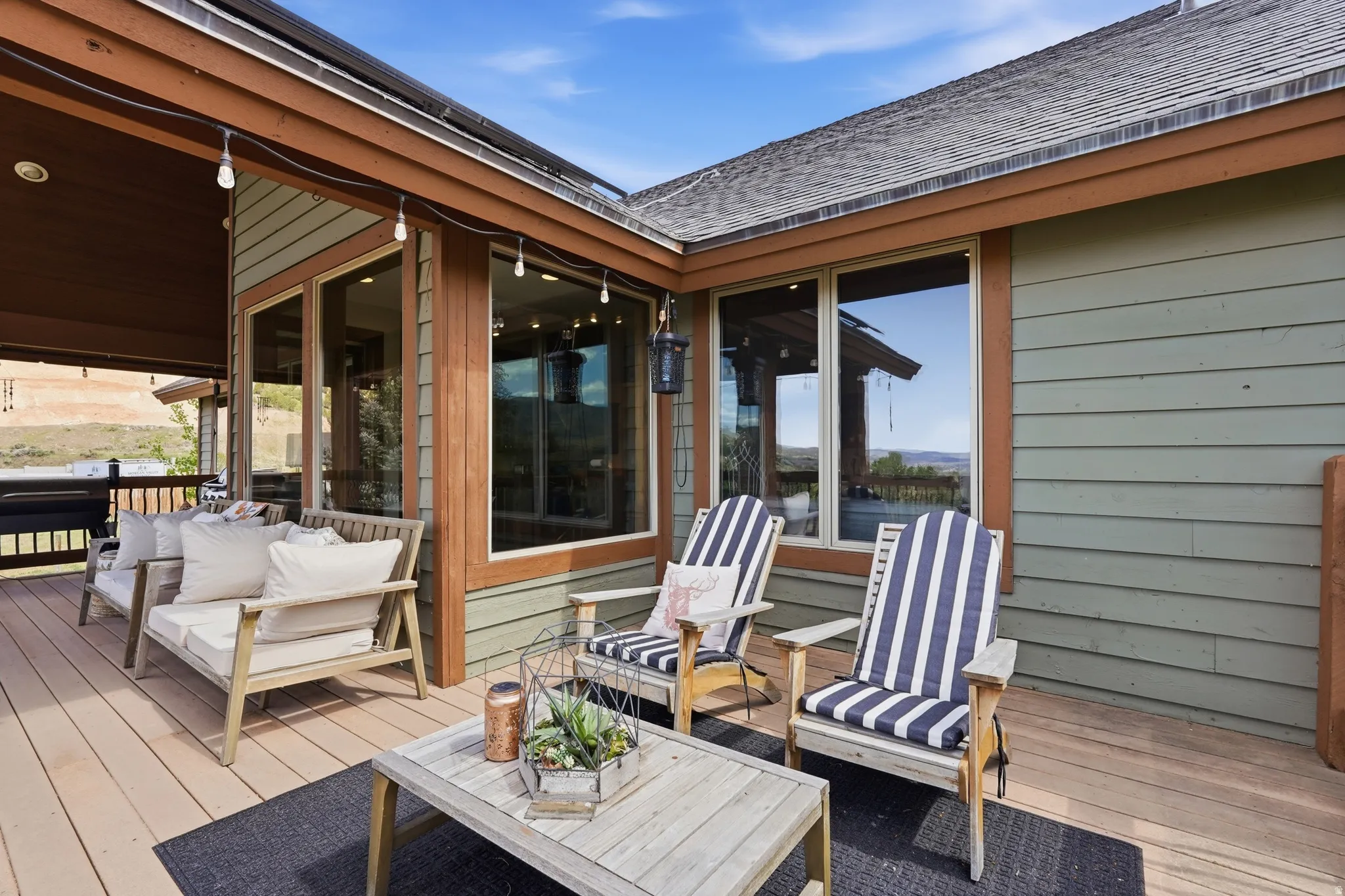 Expansive outdoor deck featuring wood-finish flooring and a partial roof overhang