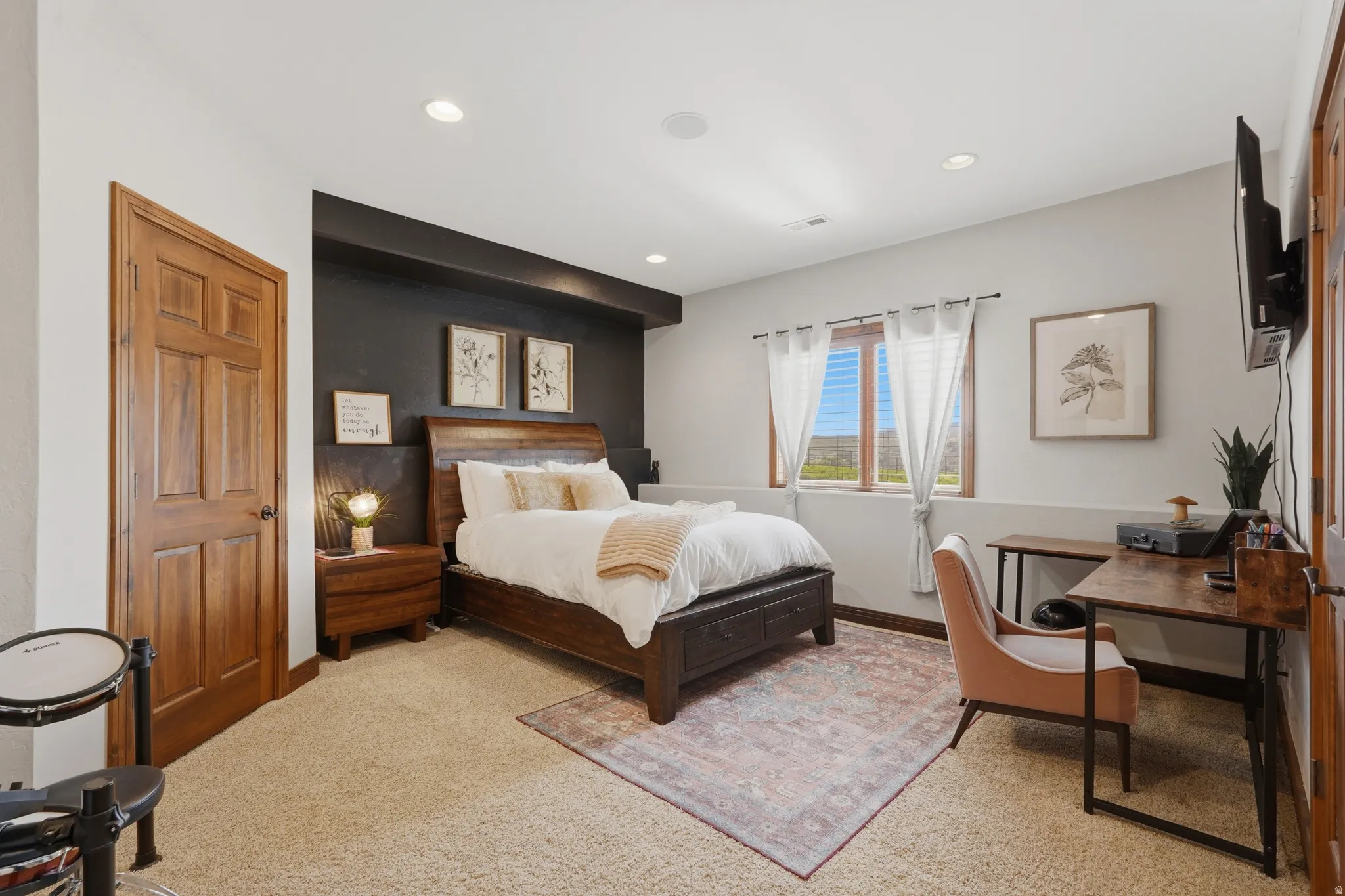 Carpeted room with recessed lighting and a wood-paneled door