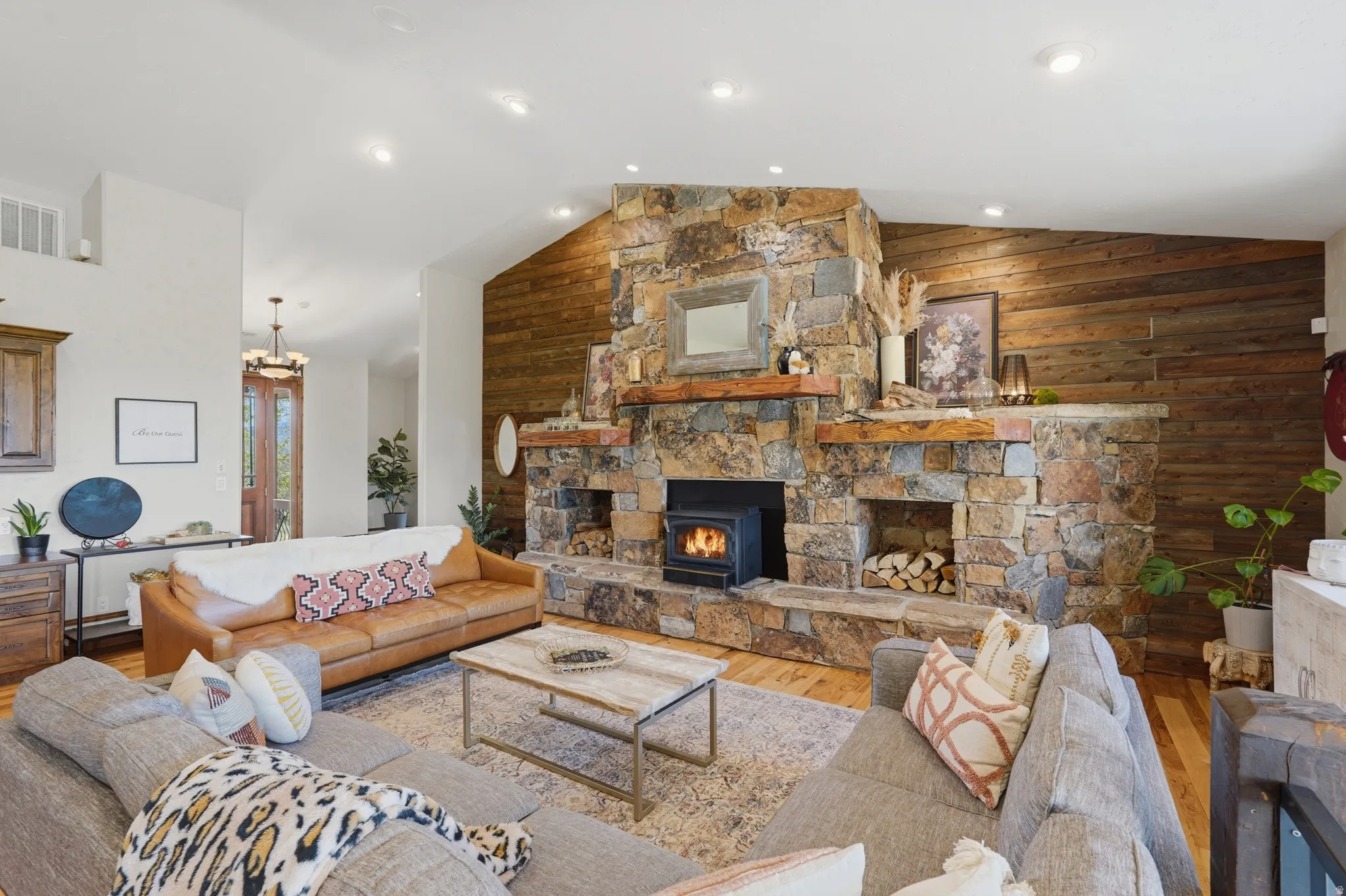 Stone-clad fireplace with a wood-burning insert and integrated wood storage