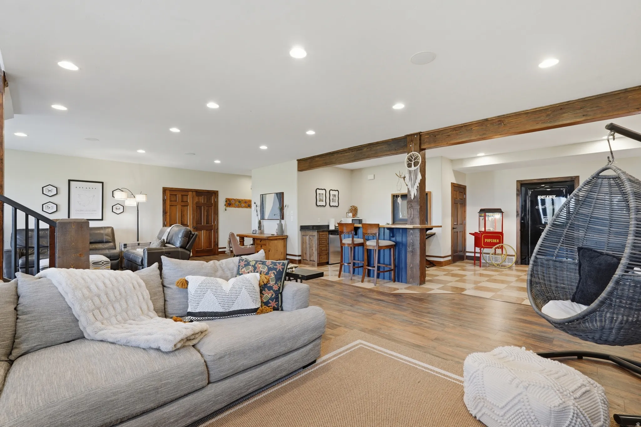 Expansive recreation space featuring wood-finish flooring, recessed lighting, and exposed ceiling beams