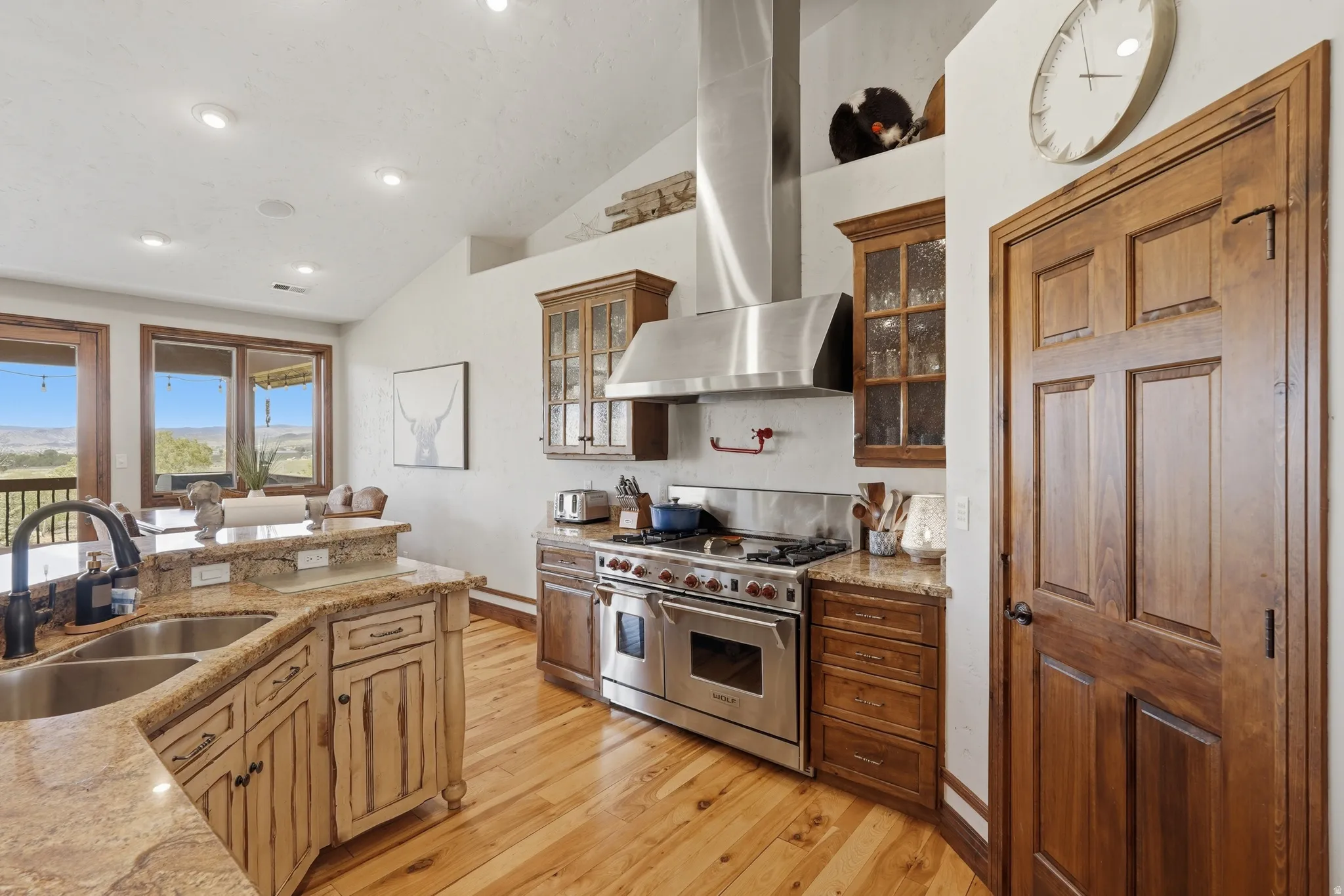 Kitchen featuring wood-finish flooring, granite countertops, and stainless steel appliances