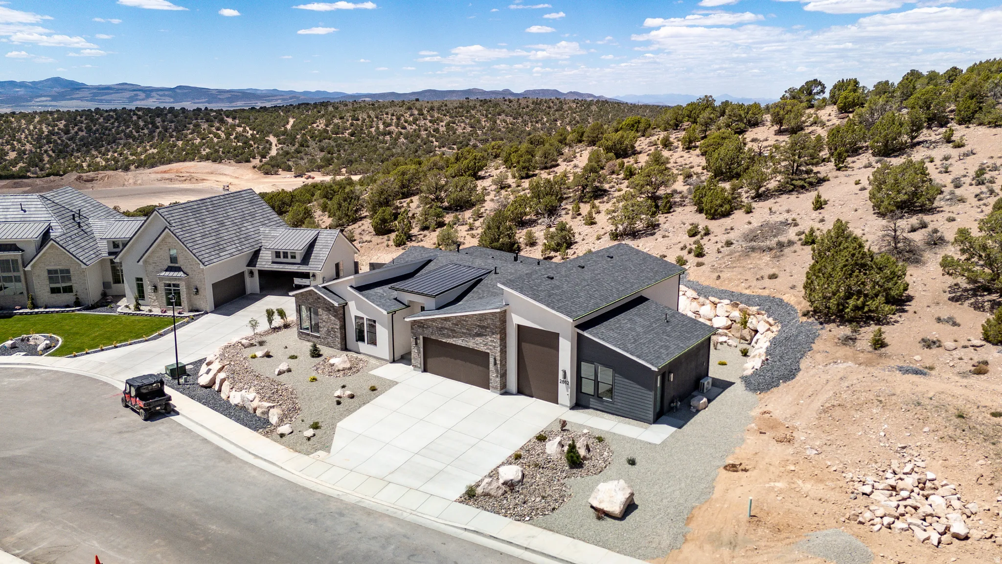 Modern architectural design featuring a multi-tone exterior, dark shingle roof, integrated solar panels, and an attached two-car garage