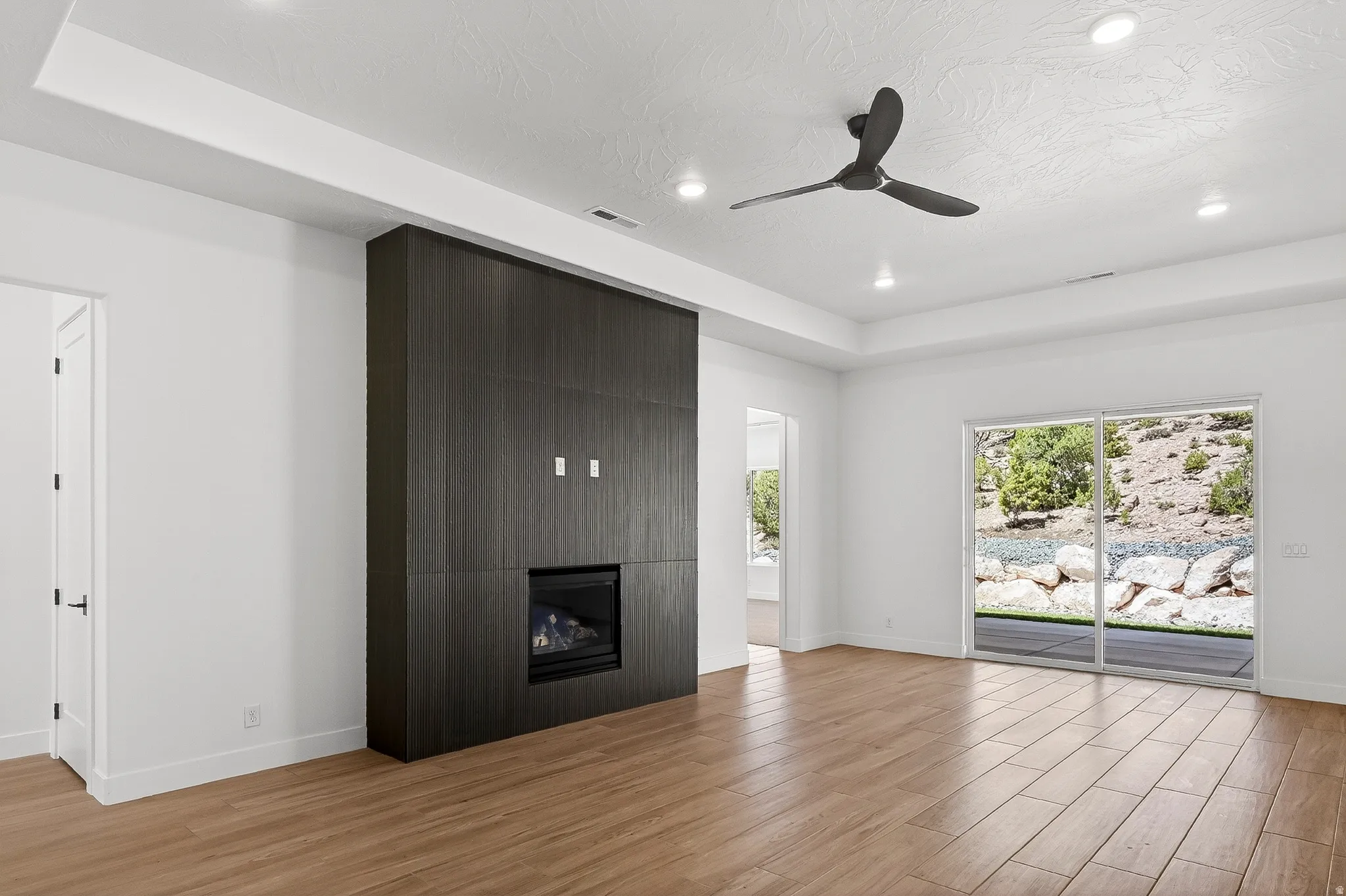 Spacious living area featuring a dark wood-finish media wall with an integrated fireplace