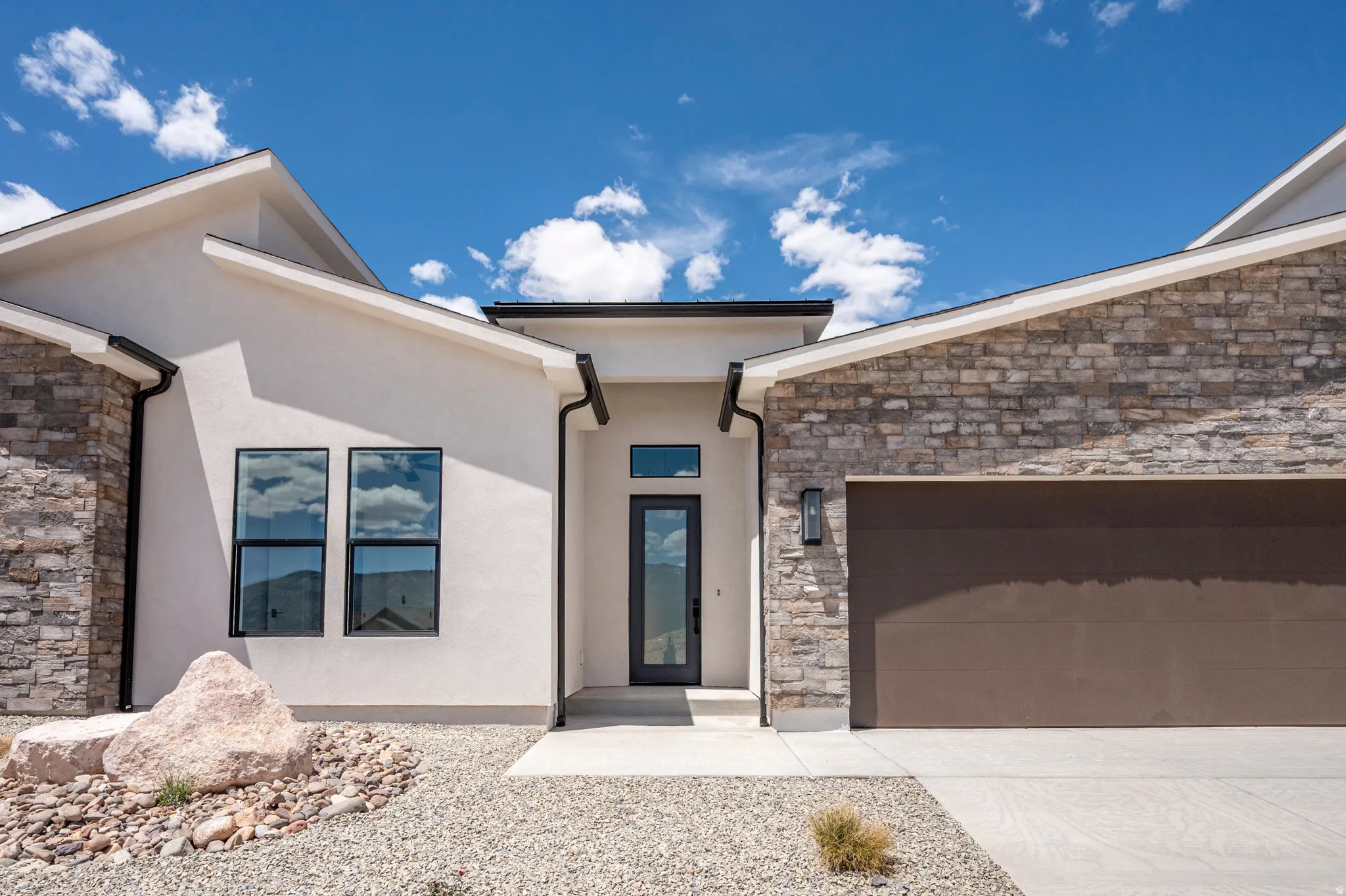 Contemporary architectural design featuring a stucco and stone facade
