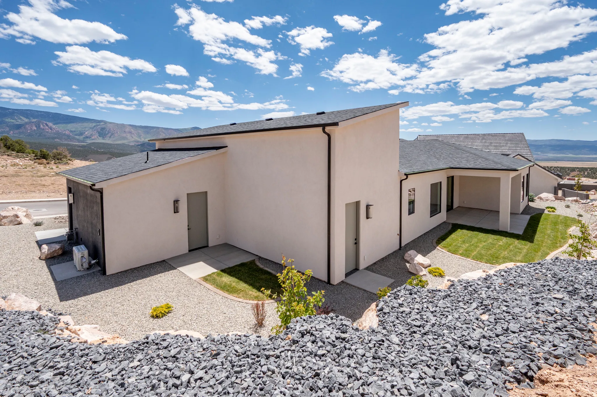 Contemporary residence featuring a stucco exterior and dark trim accents
