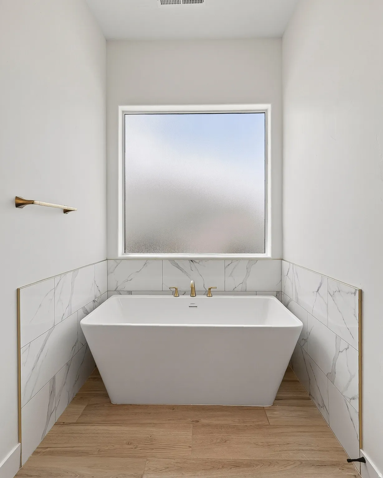 Freestanding soaking tub with gold-tone fixtures