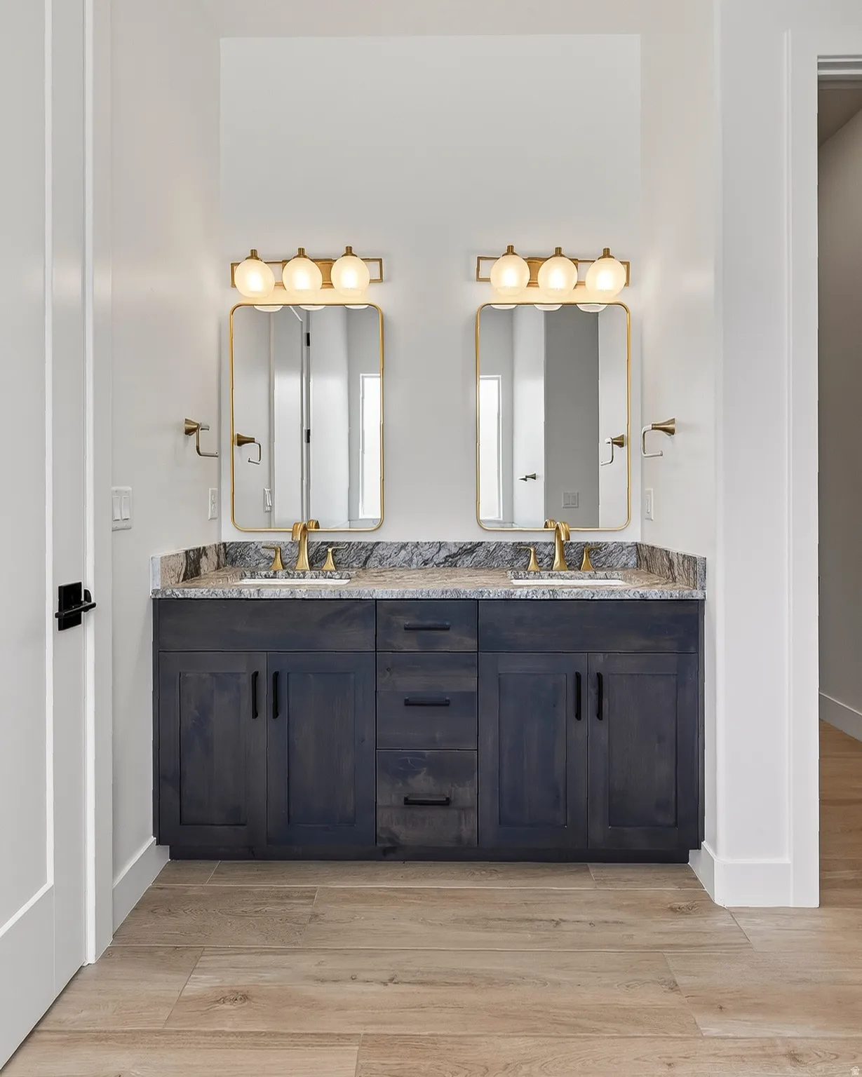 Dual vanity featuring dark wood cabinetry and a stone countertop