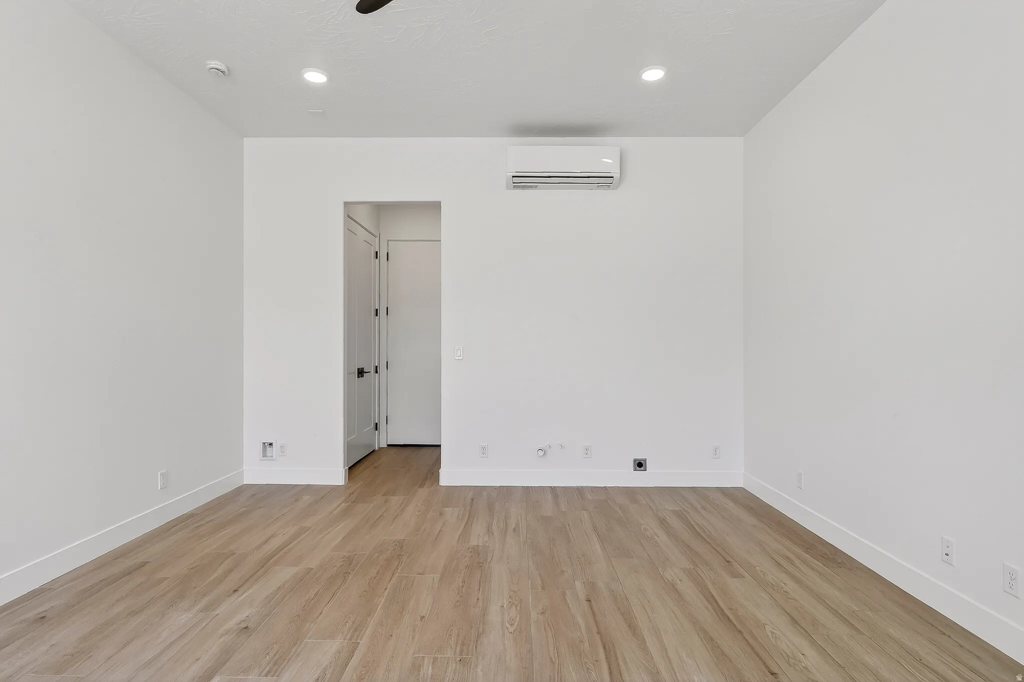 Bright interior space featuring wood-finish flooring, white walls, and recessed lighting
