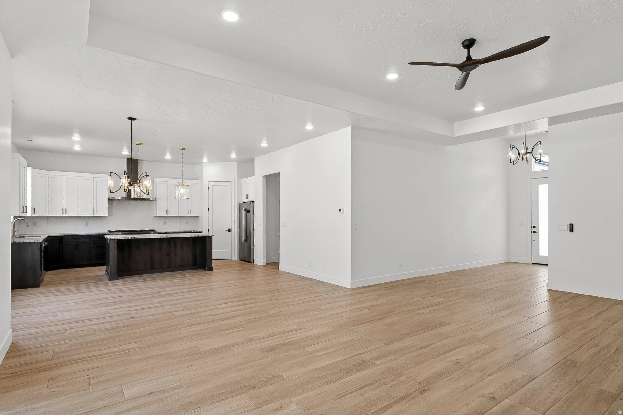 Open-concept living space featuring wood-finish flooring, recessed lighting, and a modern ceiling fan