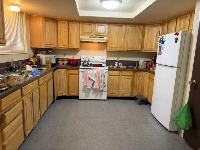 Kitchen featuring ample wood cabinetry, a built-in range, a single basin sink, and laminate countertops