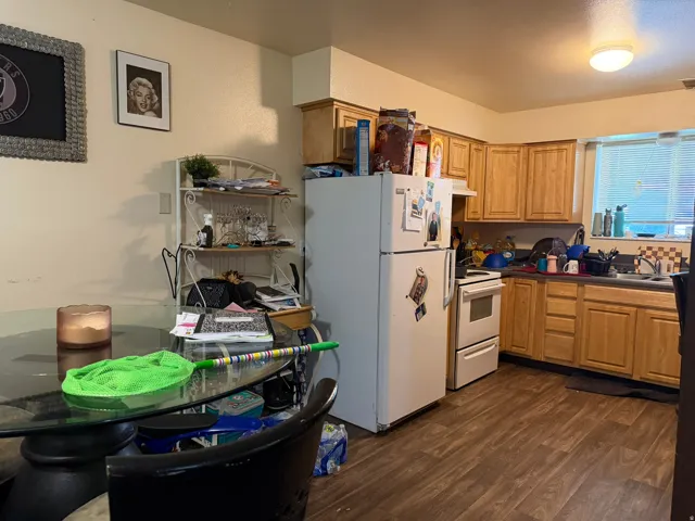 Kitchen featuring wood-finish flooring, a double-basin sink, wood cabinetry, and a window with blinds