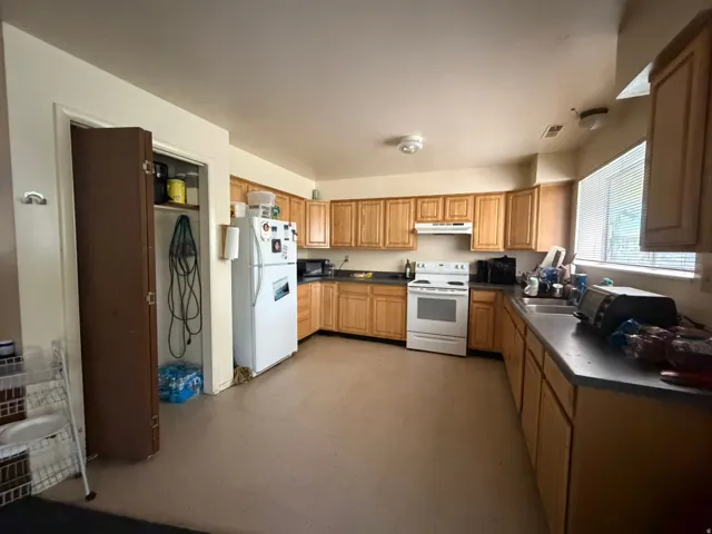 Kitchen featuring wood-finish cabinetry, dark countertops, and resilient flooring