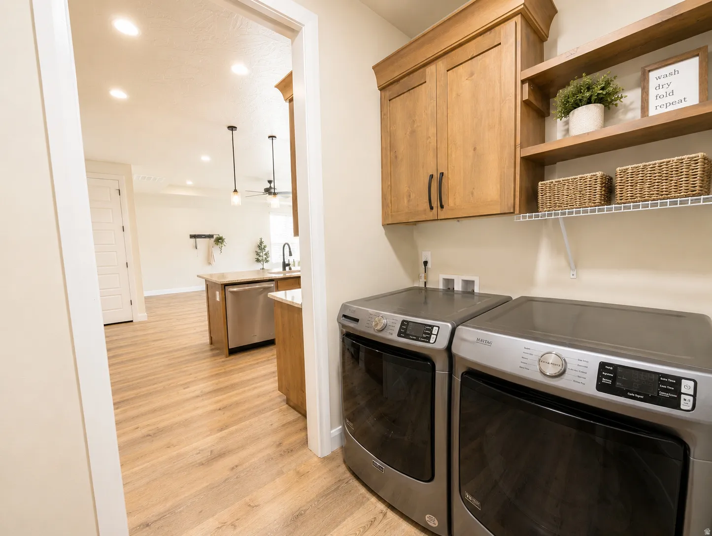 Dedicated utility area featuring wood-finish cabinetry and open shelving