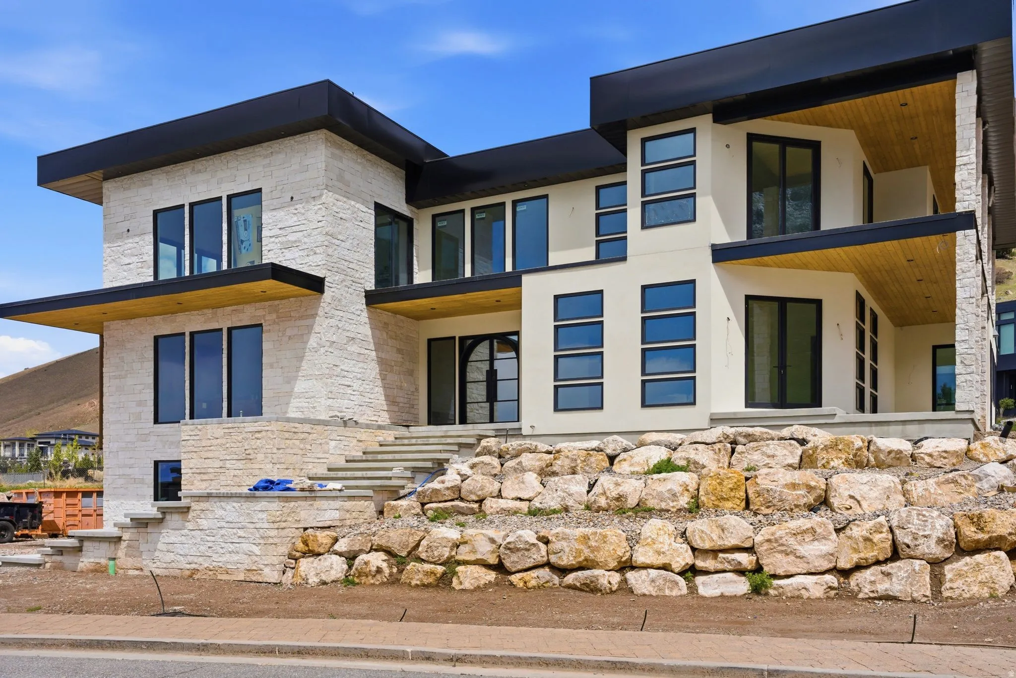 Modern architectural design featuring stacked stone and smooth stucco exterior finishes