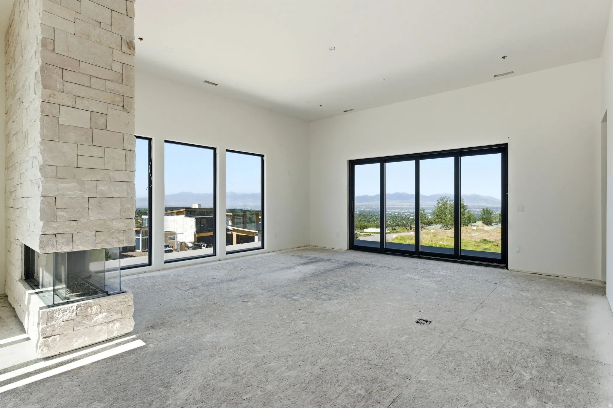 Stone-clad fireplace with a three-sided glass enclosure