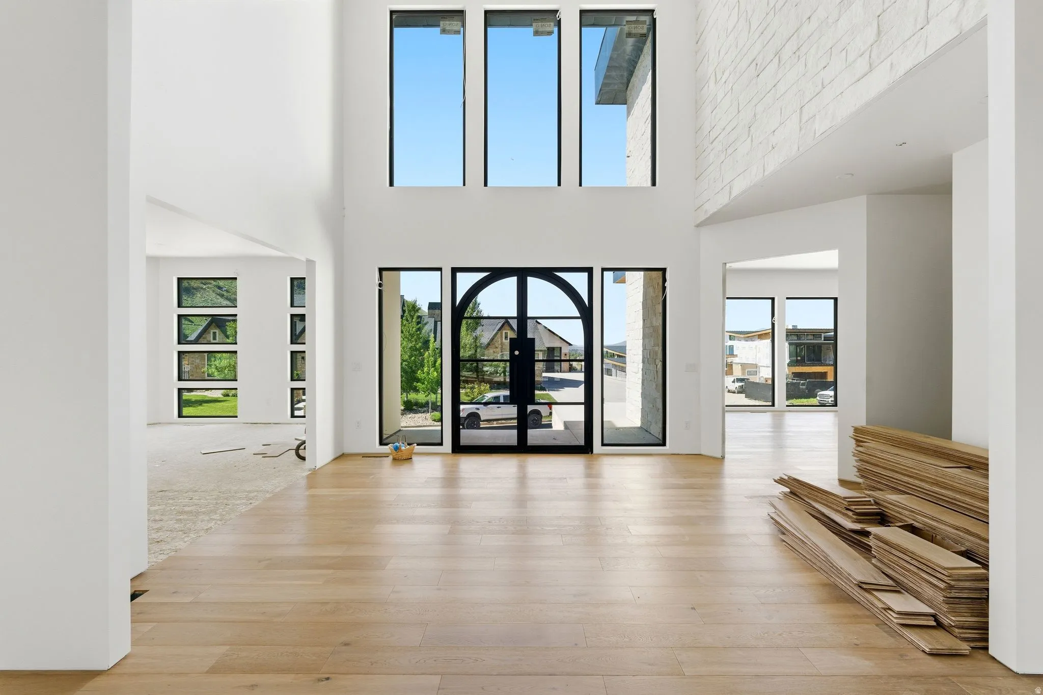 Grand entryway featuring double-height ceilings and light wood-finish flooring