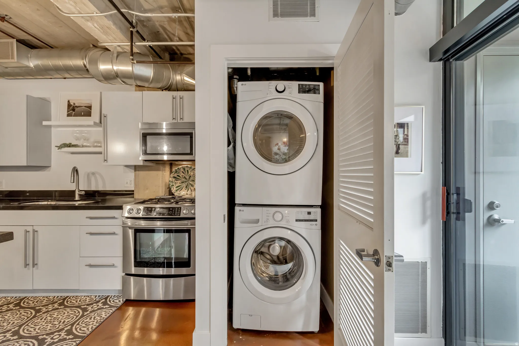 Compact laundry closet featuring a stacked washer and dryer
