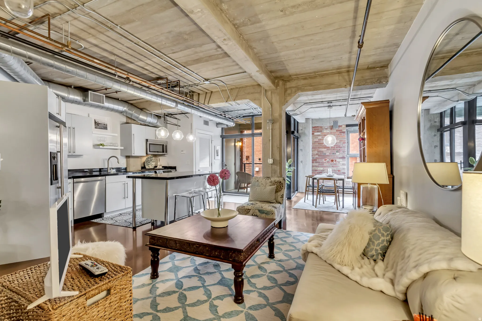 Open-concept living space with concrete ceilings and exposed ductwork