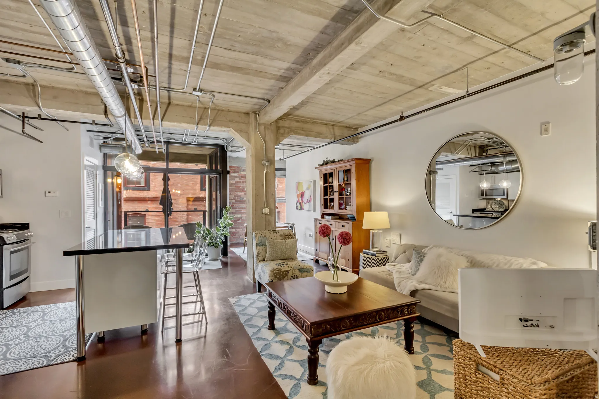 Open-concept living space featuring an exposed concrete ceiling, industrial-style ductwork, and polished concrete flooring