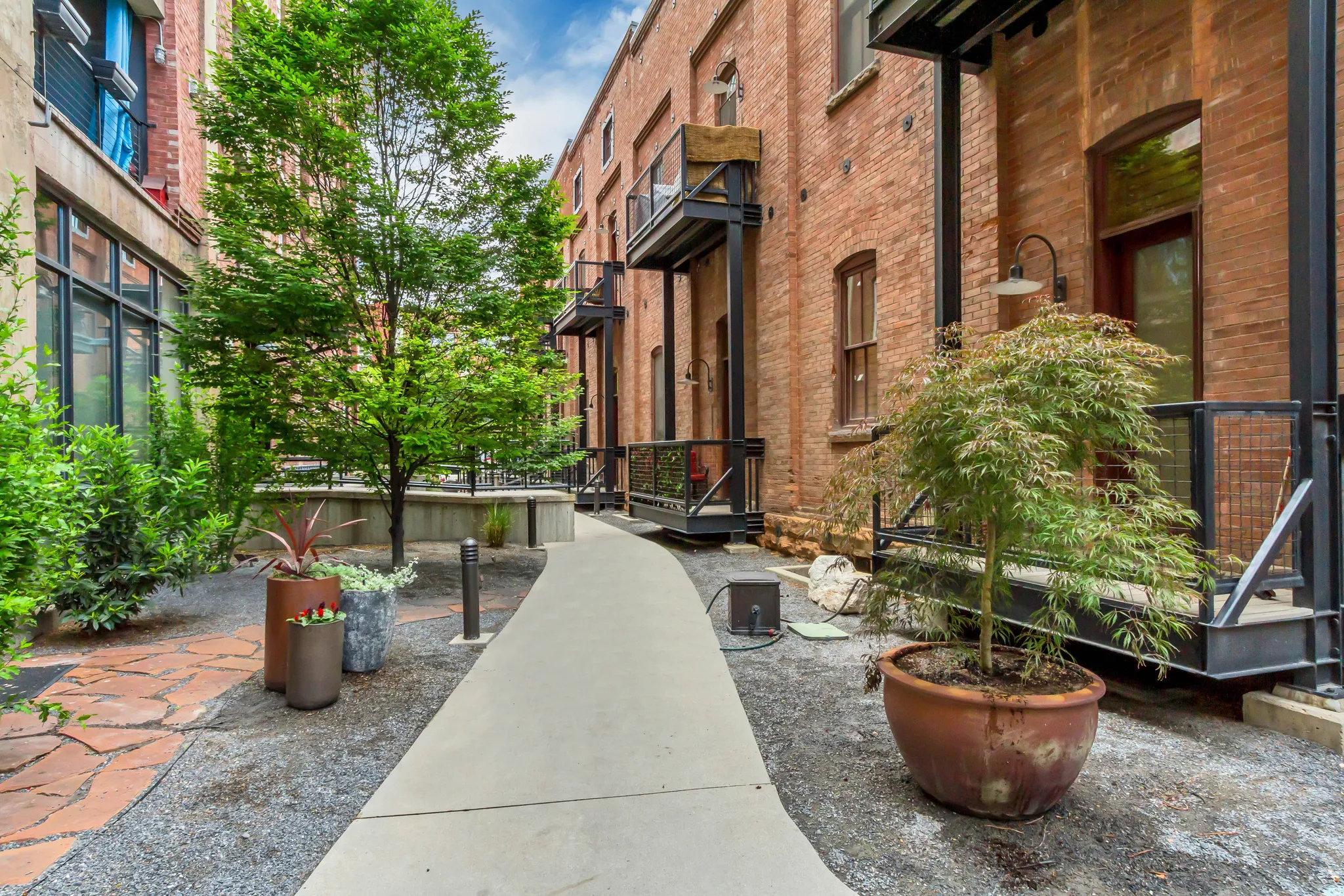 Exterior brick facade featuring private balconies with black metal railings