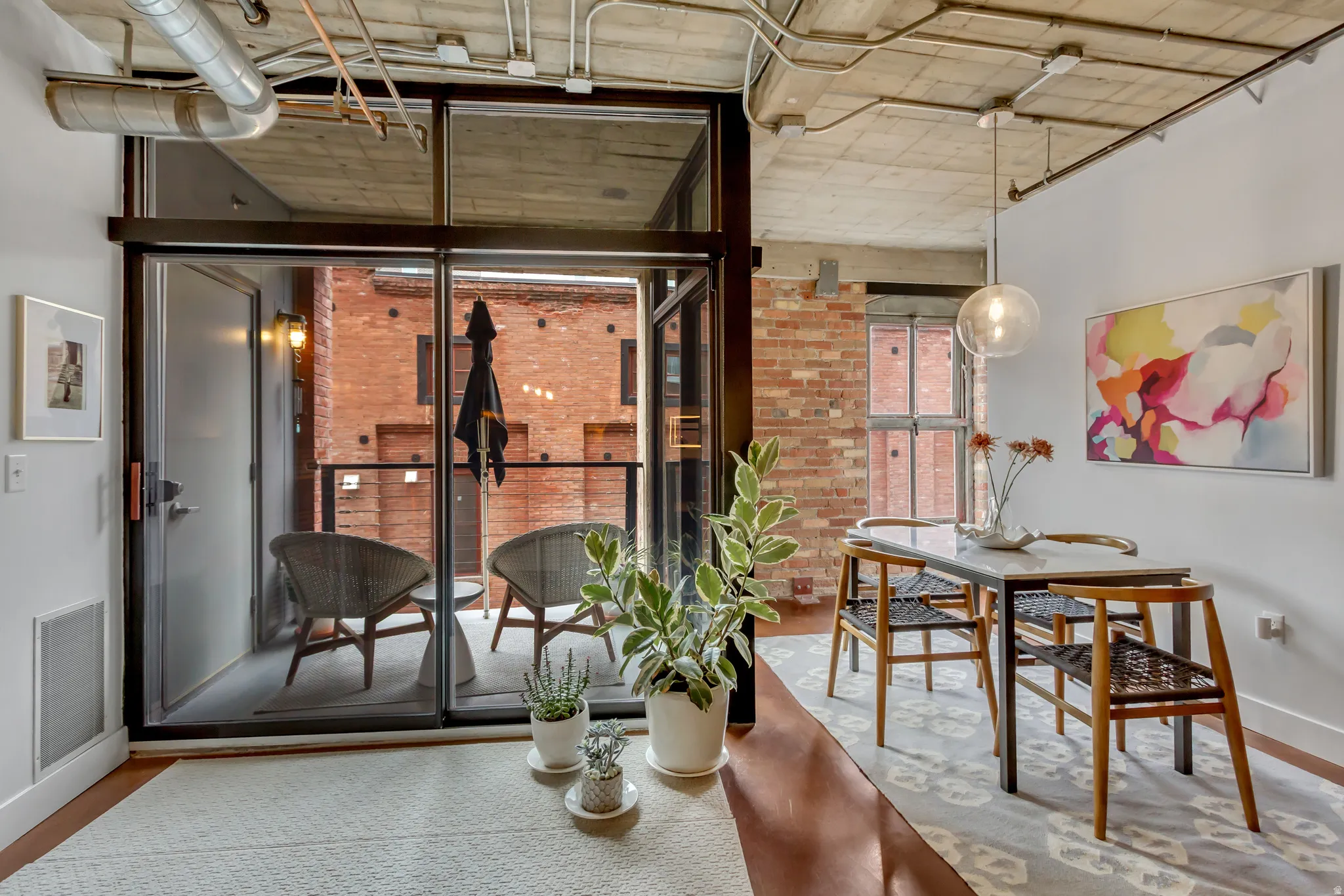 Sliding glass doors open to a private balcony with black railings
