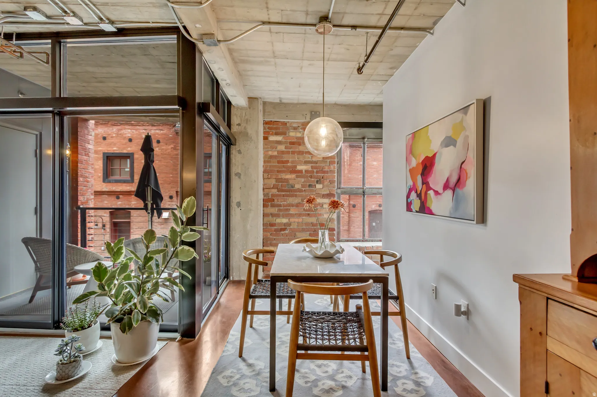 Dining area featuring an industrial-chic aesthetic with exposed brick and concrete ceilings