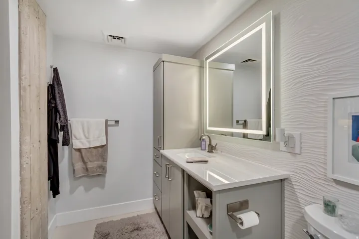 Contemporary bathroom featuring a grey vanity with a white countertop and an integrated sink