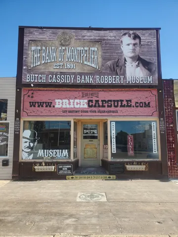 Commercial storefront building featuring prominent signage, large display windows, and a central entrance