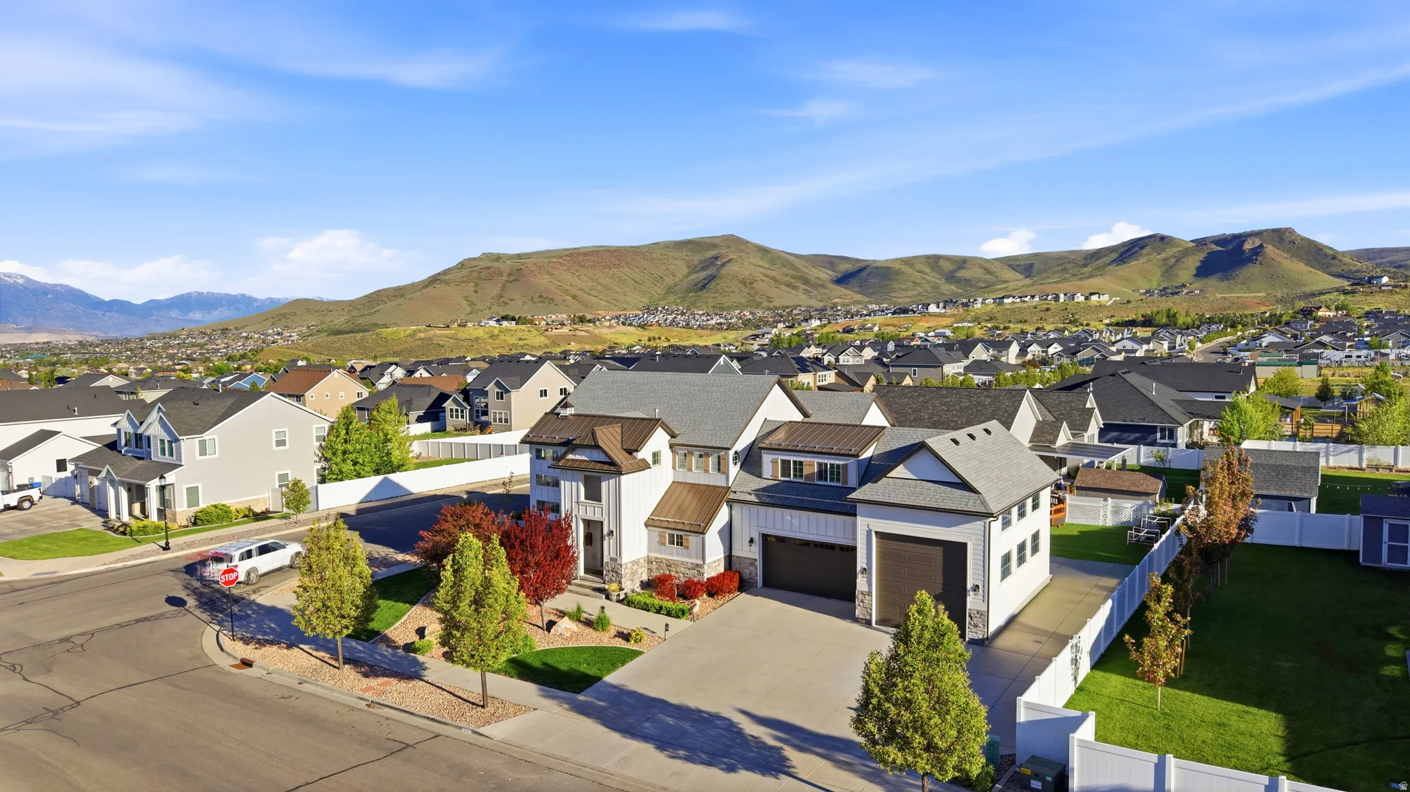 Expansive residential property featuring a multi-level design, attached two-car garage, and a long paved driveway