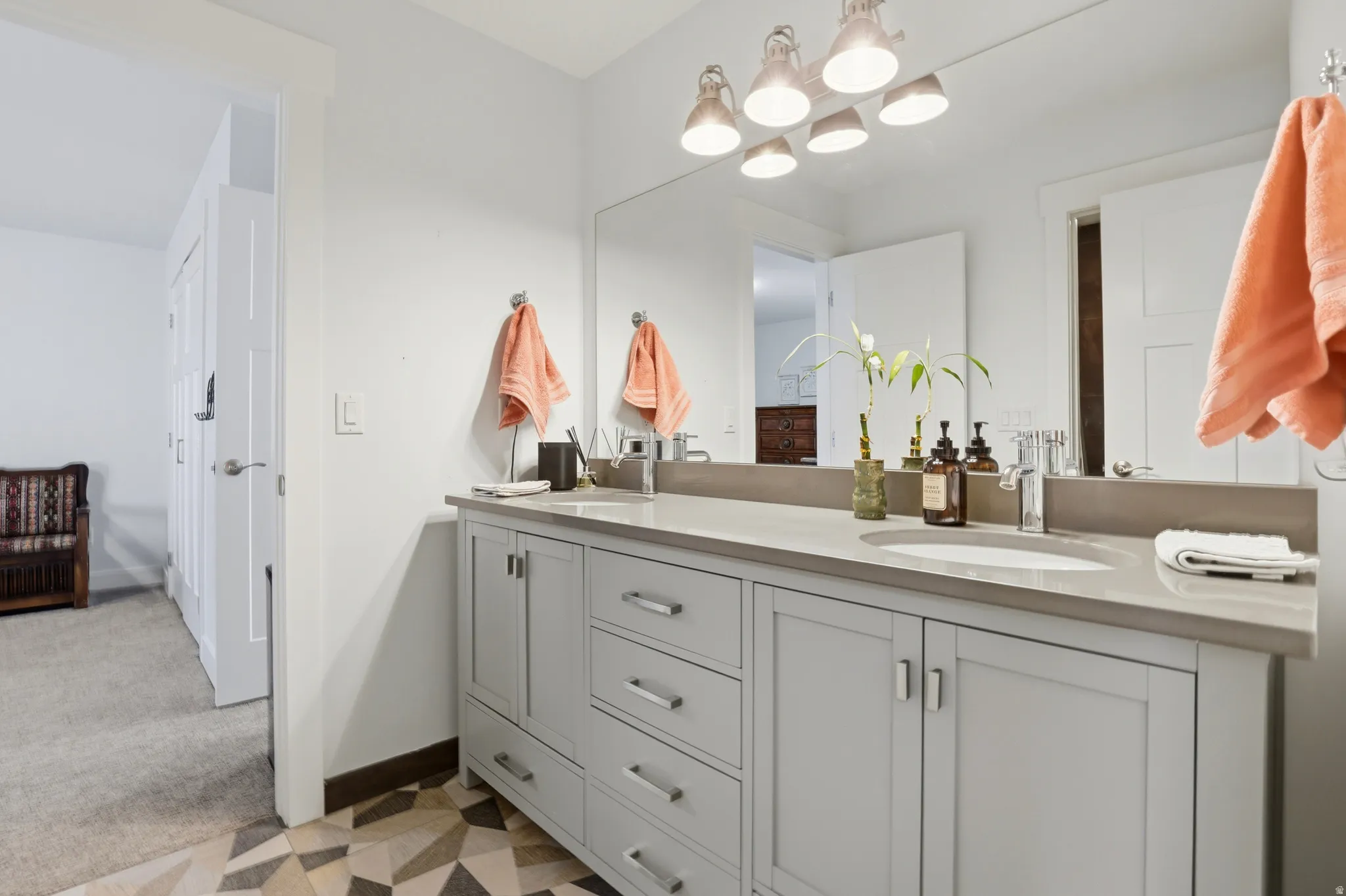 Dual sink vanity with light gray cabinetry, brushed nickel hardware, and a light gray countertop