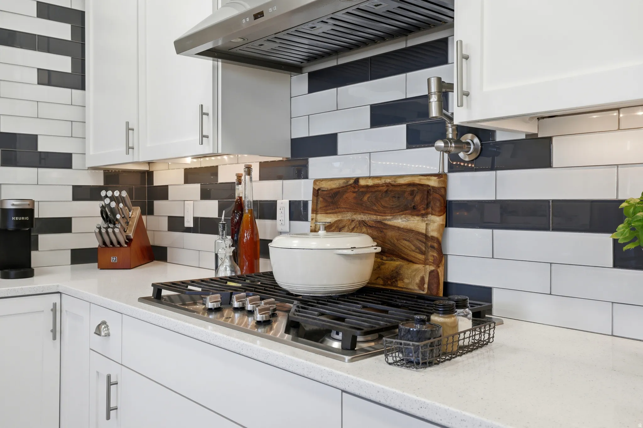 Contemporary kitchen featuring a stainless steel range hood and a gas cooktop