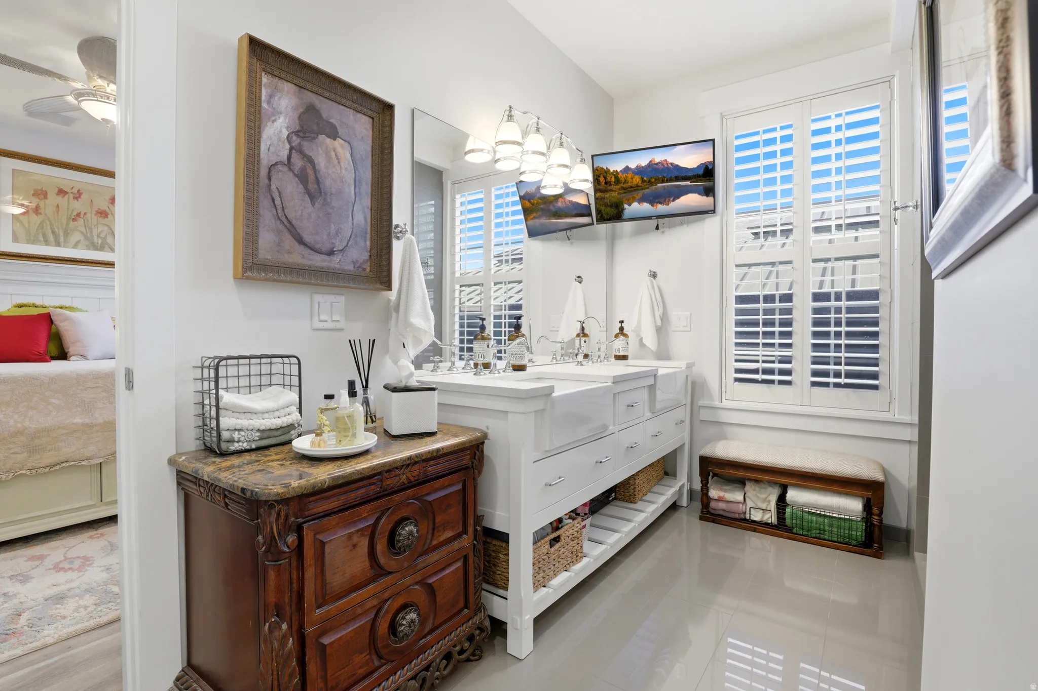 Bathroom featuring a double vanity with integrated sinks, ample storage, and a wall-mounted display