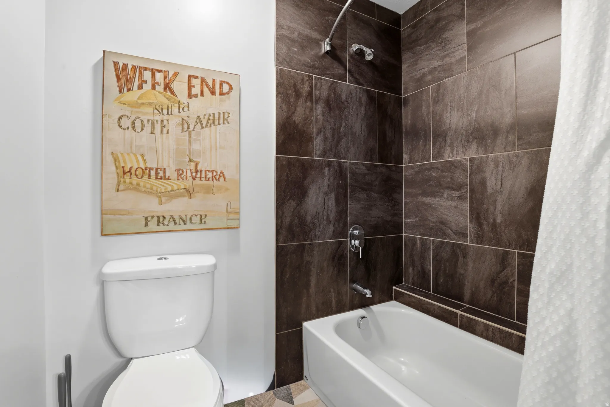 Bathroom featuring a white tub, shower with dark brown tile surround, chrome fixtures, and a white toilet