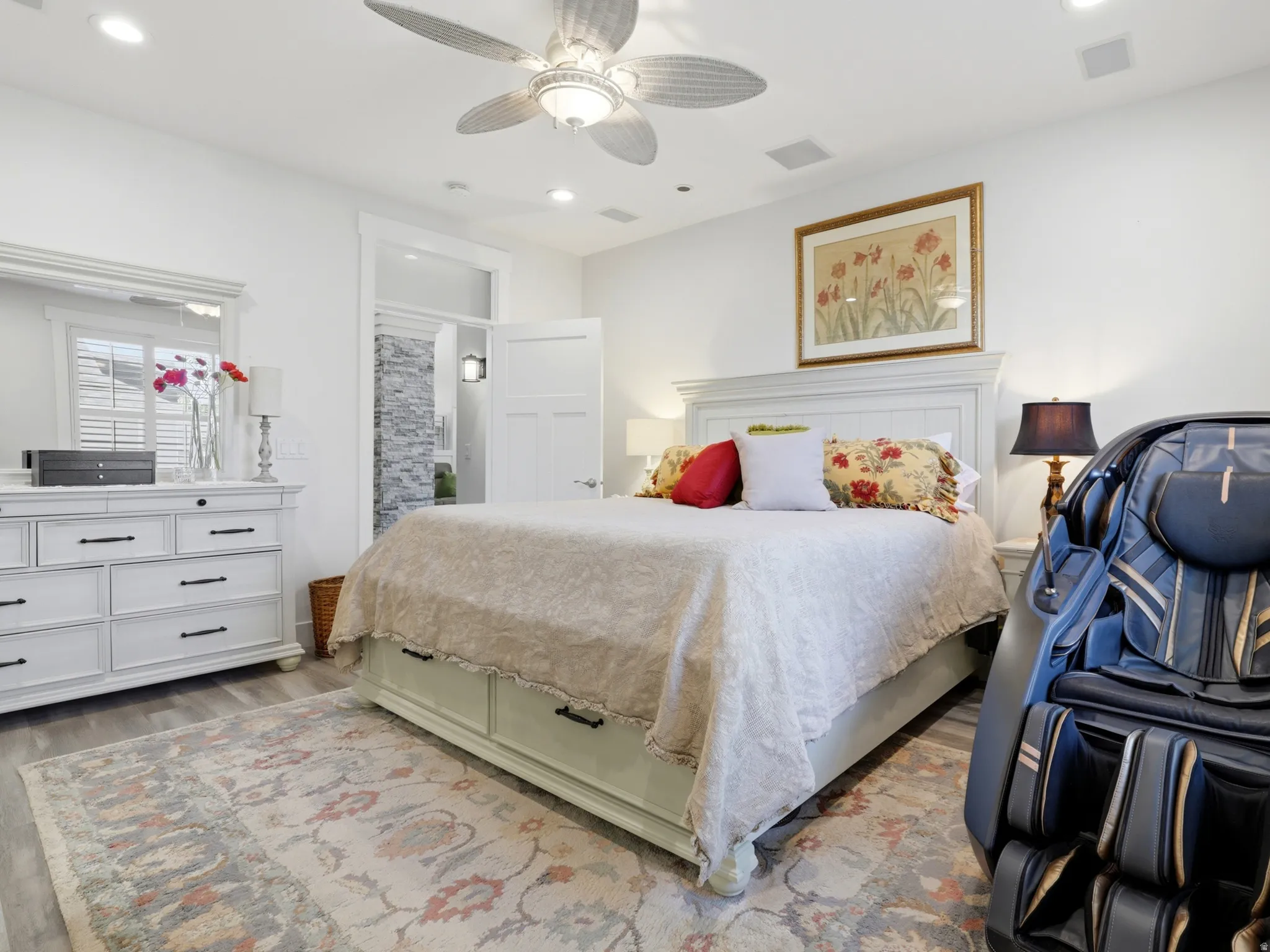 Bedroom featuring wood-finish flooring, a white paneled headboard, and recessed lighting