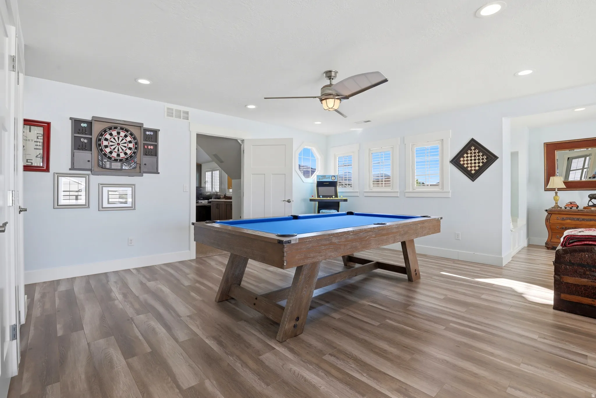 Spacious recreation room featuring wood-finish flooring, recessed lighting, and a ceiling fan