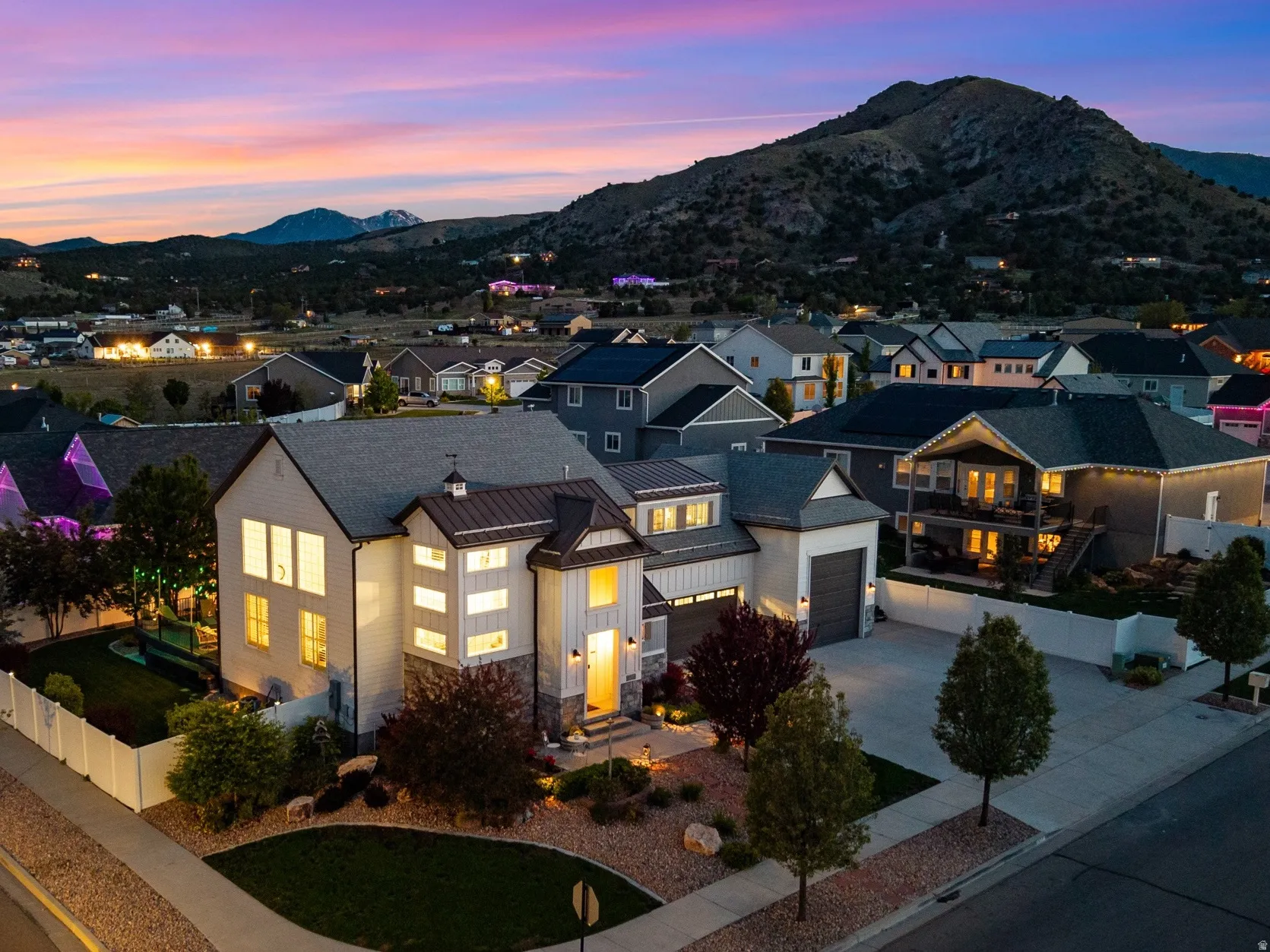 Modern farmhouse-style residence featuring a prominent gabled roofline, board and batten siding, and stone accents