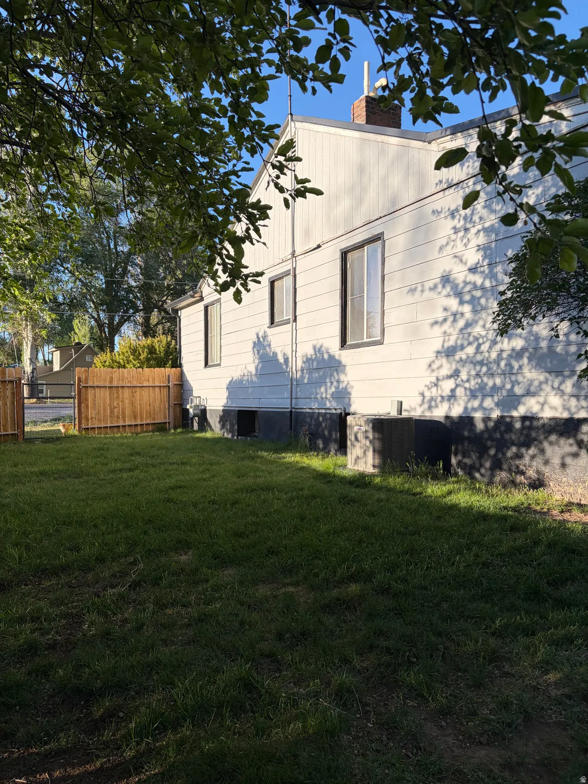 Expansive grassy yard with a wood fence bordering the property