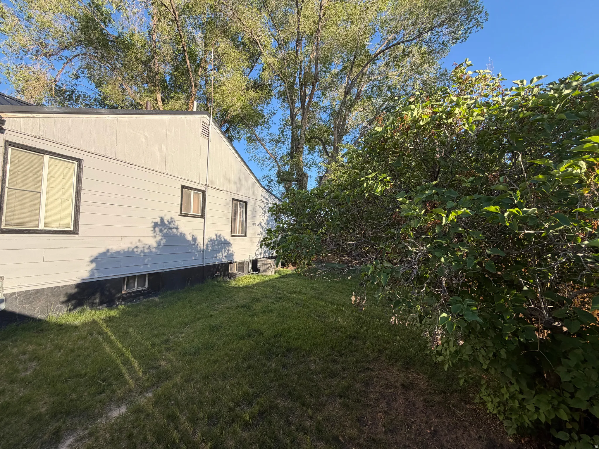 Light gray siding with dark trim windows and a dark foundation