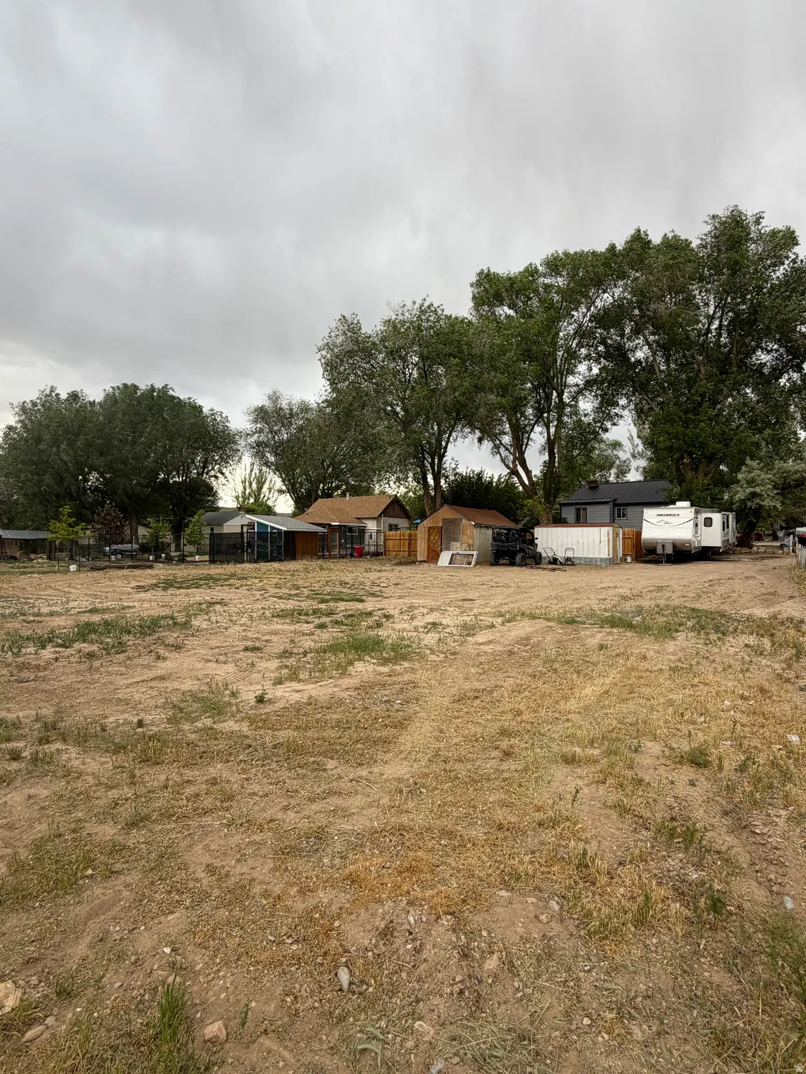 Expansive undeveloped land featuring natural terrain and distant mature trees