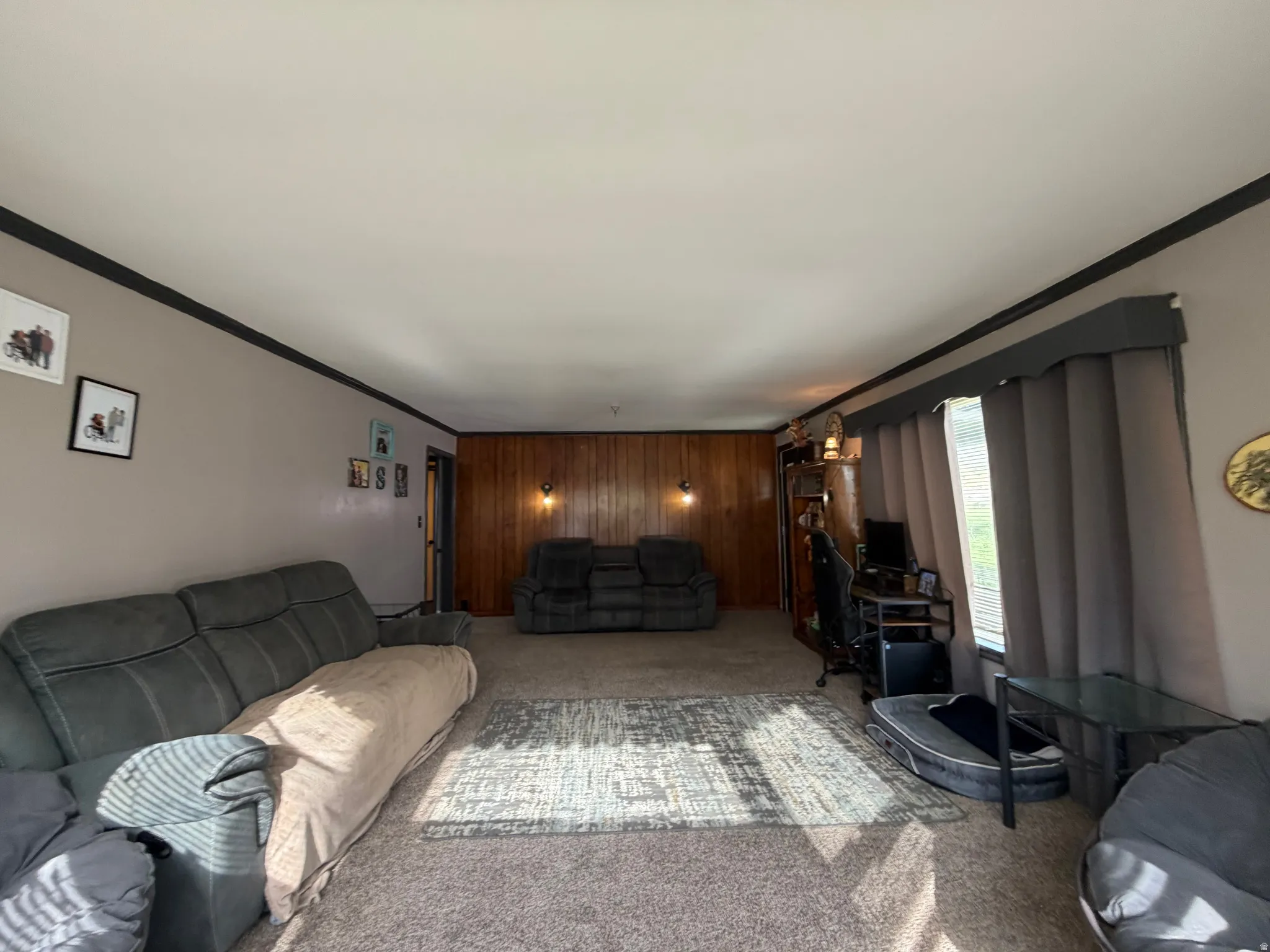 Spacious interior with neutral-toned walls, contrasting dark trim, and a prominent wood-paneled accent wall
