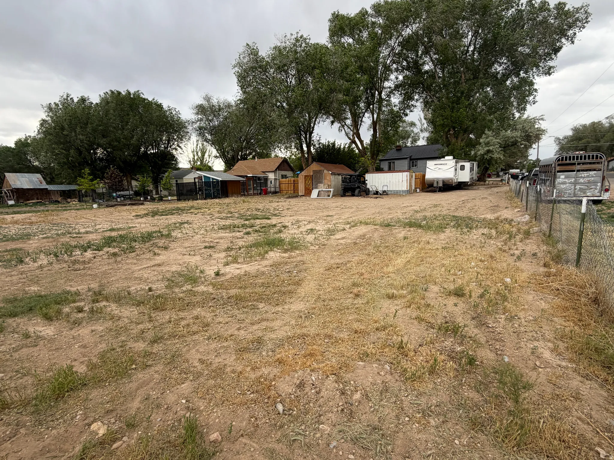 Expansive undeveloped lot featuring a natural earth surface and mature perimeter trees