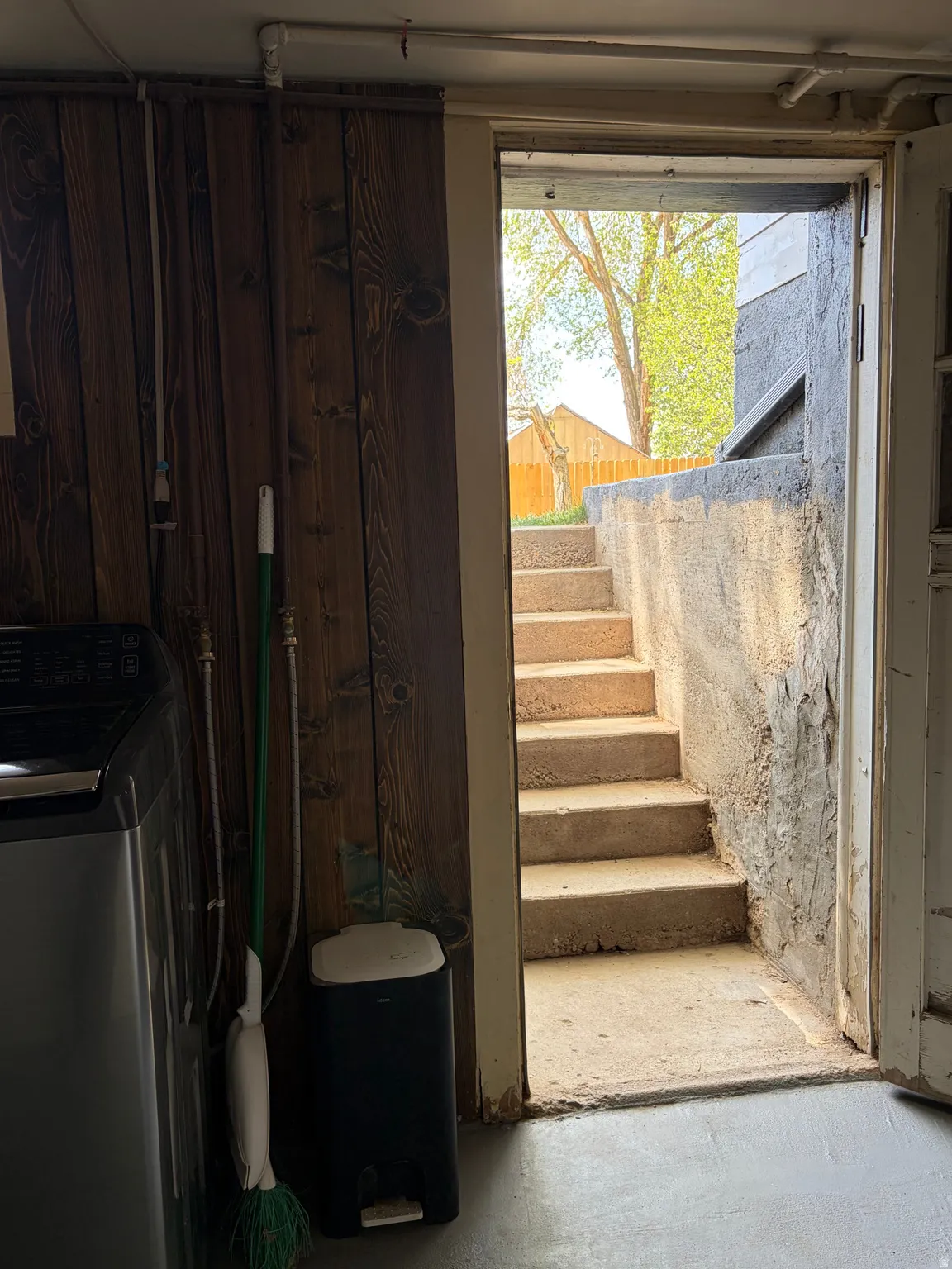 Exterior access stairway with concrete steps and a concrete retaining wall