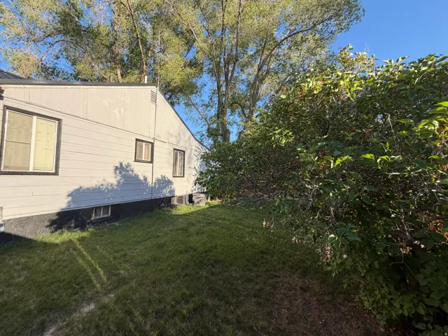 Light gray siding with dark trim windows and a dark foundation