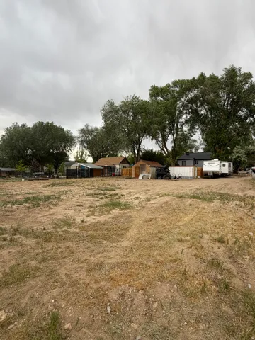 Expansive undeveloped land featuring natural terrain and distant mature trees